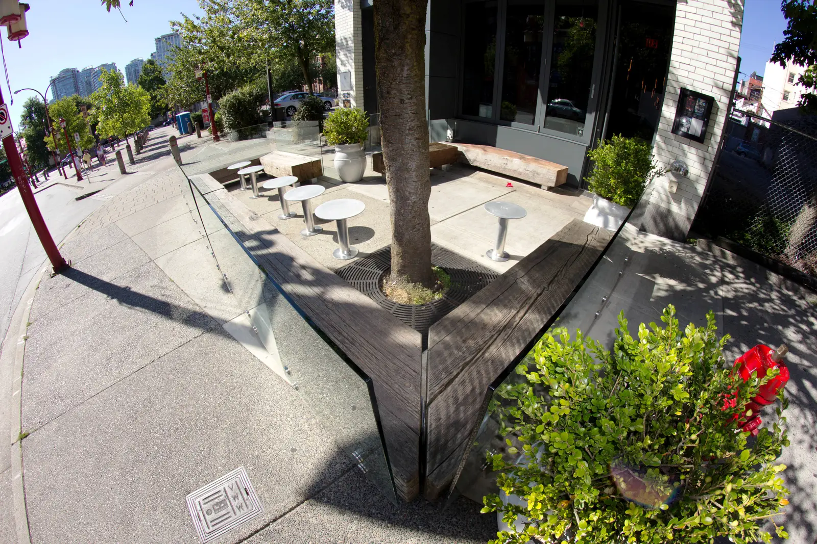 Reclaimed-timber parklet benches and planter surround on a Vancouver street corner