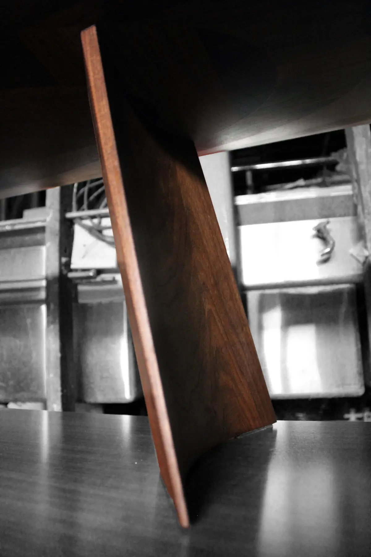 The tapered edge of a Swell tabletop and the curve of its base, seen from below