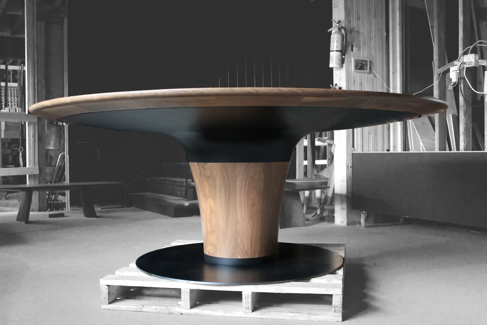 Round Swell pedestal table in walnut and blackened steel at the Chapel Arts shop