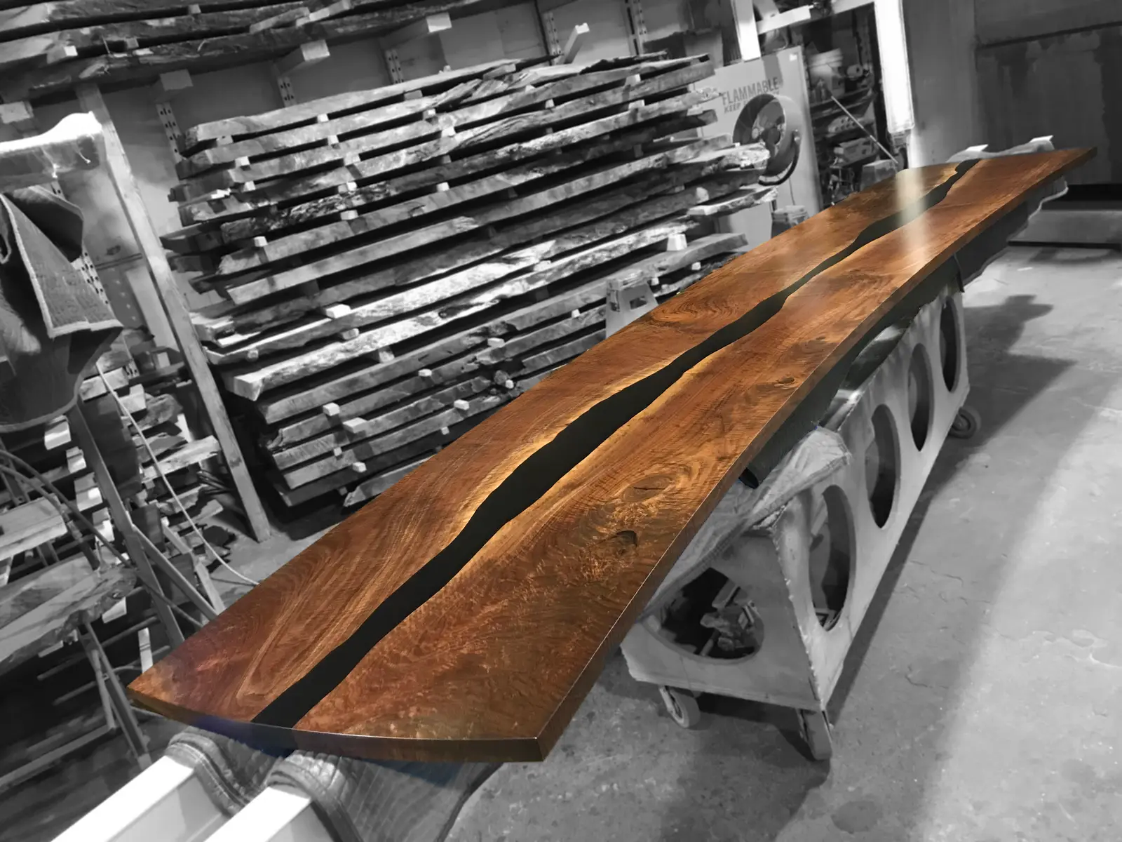 Long walnut table with a CNC-cut, resin-cast river channel, fresh off the machines